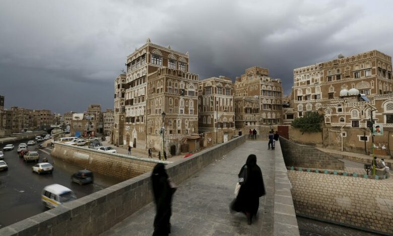 women walk on a bridge in the old quarter of yemen's capital sanaa